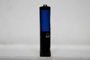 Single AAA-Size Battery Standing Upright on a White Surface photo