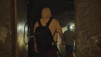 une homme avec une sac à dos va vers le bas le escaliers à un souterrain bunker video
