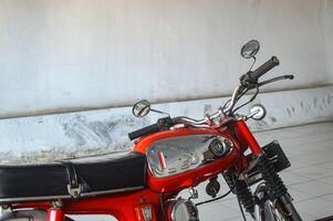 an old classic red Honda S90Z motorbike, Indonesia, 2 October 2023. photo