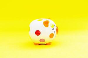 Piggybank on a yellow background. to save , saving money for affordable things, financial concept .Piggybank or deposit box on a wood background, depict saving money to make a trust fund for children photo