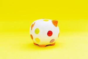 Piggybank on a yellow background. to save , saving money for affordable things, financial concept .Piggybank or deposit box on a wood background, depict saving money to make a trust fund for children photo