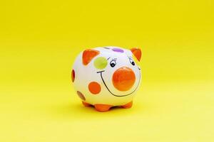 Piggybank on a yellow background. to save , saving money for affordable things, financial concept .Piggybank or deposit box on a wood background, depict saving money to make a trust fund for children photo