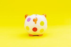 Piggybank on a yellow background. to save , saving money for affordable things, financial concept .Piggybank or deposit box on a wood background, depict saving money to make a trust fund for children photo