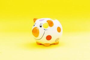 Piggybank on a yellow background. to save , saving money for affordable things, financial concept .Piggybank or deposit box on a wood background, depict saving money to make a trust fund for children photo