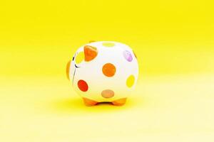 Piggybank on a yellow background. to save , saving money for affordable things, financial concept .Piggybank or deposit box on a wood background, depict saving money to make a trust fund for children photo