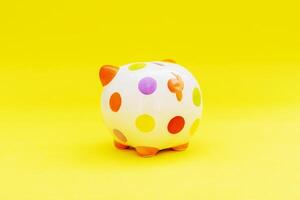 Piggybank on a yellow background. to save , saving money for affordable things, financial concept .Piggybank or deposit box on a wood background, depict saving money to make a trust fund for children photo