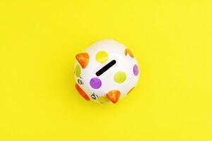 Piggybank on a yellow background. to save , saving money for affordable things, financial concept .Piggybank or deposit box on a wood background, depict saving money to make a trust fund for children photo