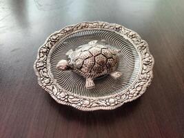 un plata tortuga en un plata plato es un símbolo de bueno suerte, sabiduría, proteccion, transformación, y longevidad según a vastú shastra. foto