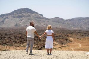 A couple in love hold hands in the crater of the Teide volcano.Tenerife, Canary Islands photo