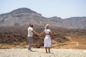 A couple in love hold hands in the crater of the Teide volcano.Tenerife, Canary Islands photo