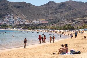 July 25, 2019 Tenerife, Spain, Canary Islands, People vacationing on the sandy beach of the island of Tenerife photo