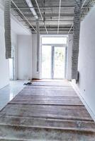 Reconstruction of a new building. Room under repairmen. Concrete floor and walls. Full length photo