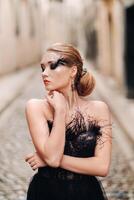 A stylish bride in a black wedding dress poses in the ancient French city of Avignon. Model in a beautiful black dress. Photo shoot in Provence.