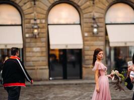 un joven hermosa novia soportes a el centrar de el antiguo ciudad de florencia en Italia. novia en un hermosa rosado vestir con un ramo de flores en toscana.italia foto