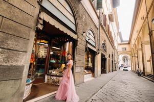 un joven hermosa novia soportes a el centrar de el antiguo ciudad de florencia en Italia. novia en un hermosa rosado vestir en toscana.italia foto