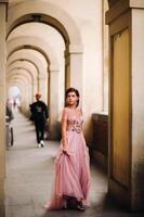 un joven hermosa novia soportes a el centrar de el antiguo ciudad de florencia en Italia. novia en un hermosa rosado vestir en toscana.italia foto