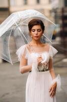 A beautiful stylish bride with an umbrella walks through the old city of Florence.Model with umbrellas in Italy.Tuscany. photo