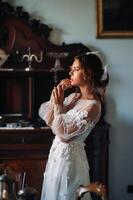un novia en ropa interior y un blanco túnica en el interior de un villa en Italia a un boda.mañana de el novia en toscana.boudoir foto sesión a el villa.