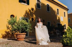 Stylish young bride on her wedding day in Italy.elegant Bride from Tuscany.Bride in a white wedding dress photo