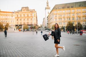 elegante joven niña en un negro vestir y chaqueta en el antiguo pueblo de brno. checo foto