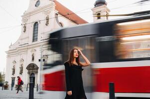 elegante joven niña en un negro vestir en urbano estilo en el calle de el ciudad de brno. checo foto