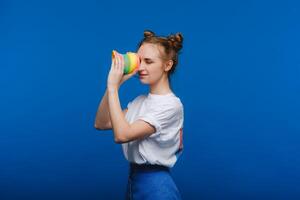 hermosa joven niña jugando con un arco iris seductor, un juguete de su infancia en un azul antecedentes foto