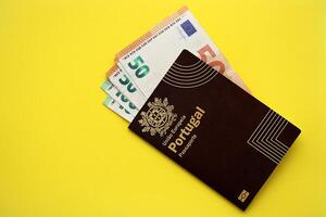 rojo Portugal pasaporte de europeo Unión y dinero en amarillo antecedentes cerca arriba foto