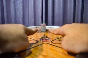 hands playing a traditional game called carom photo