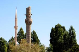 un antiguo destruido alminar y un sólido alminar foto