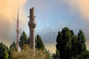 un antiguo destruido alminar y un sólido alminar foto