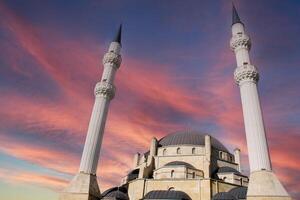 A large white mosque with two minarets. islamic architecture photo