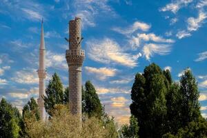 un antiguo destruido alminar y un sólido alminar foto