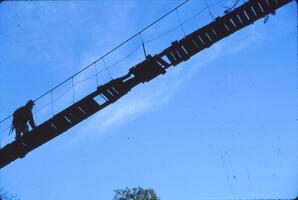 Hiker crossing suspension bridge photo