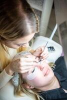 Eyelash extension procedure in beauty salon. Lashes close up. Concept spa lash. photo