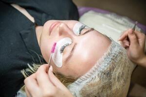 Eyelash extension procedure in beauty salon. Lashes close up. Concept spa lash. photo