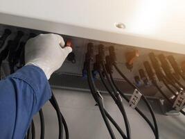 A engineering checking string cable lines in inverter solar panel.The Hand hold a string cable for check and repair. Inverter service concept for technology  background. photo