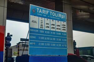 Board listing Trans Java toll road costs based on vehicle in Surabaya, indonesia, 17 November 2023. photo