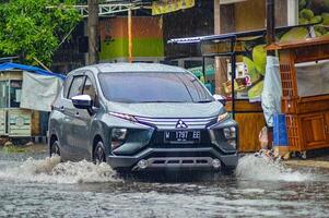 a Mitsubishi Expander car that hit a flood during heavy rain on a residential street, Indonesia, 8 December 2023. photo