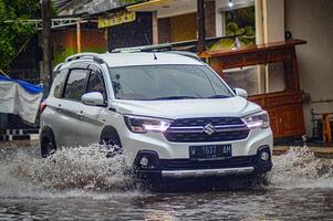 a Suzuki Ertiga car that crashed into a flood during heavy rain on a residential street, Indonesia, 8 December 2023. photo