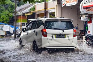 a Daihatsu Sigra car that hit a flood during heavy rain on a residential road, Indonesia, 8 December 2023. photo