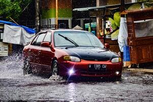 a Hyundai Excel car that crashed into a flood during heavy rain on a residential street, Indonesia, 8 December 2023. photo