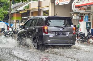 a Daihatsu Sigra car that crashed into floodwater during heavy rain on a residential street, Indonesia, 8 December 2023. photo