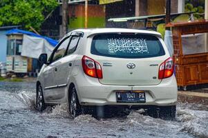 a Toyota Agya car that crashed into a flood during heavy rain on a residential street, Indonesia, 8 December 2023. photo