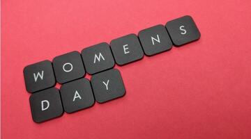 Words women's day made of black keyboard keys on red background. photo