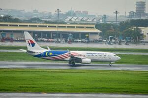 un boeing 737-8fz aeronave pertenencia a Malasia aerolínea toma apagado en el pista a juanda internacional aeropuerto surabaya en sidoarjo durante el lluvia, Indonesia, 6 6 enero 2024 foto