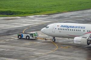 un boeing b737-8fz aeronave pertenencia a Malasia aerolínea es emprendedor espalda en el delantal de juanda internacional aeropuerto surabaya en sidoarjo, Indonesia, 6 6 enero 2024 foto