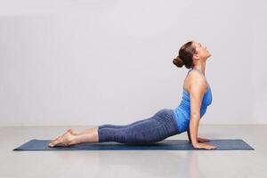 mujer haciendo Ashtanga vinyasa yoga asana urdhva mukha svanasana foto