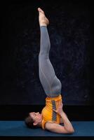 Woman doingh Ashtanga Vinyasa Yoga inverted asana Salamba sarvan photo