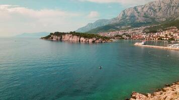 adriático costeiro Cidade dentro Croácia. Makarska Riviera se aquece dentro luz solar com a do Adriático azul mar complementando biokovo montanha. video
