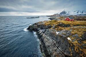 Clif con tradicional rojo rorbu casa en lofoten islas, Noruega foto